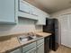 This kitchen features blue cabinets, laminate countertops, and black appliances at 907 Olde Mill Ln, Norcross, GA 30093