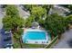 Community pool aerial view surrounded by trees, lounge chairs, and landscaping at 907 Olde Mill Ln, Norcross, GA 30093