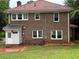 Rear exterior view of a brick home featuring a red tile roof, white trim, and grassy lawn at 1098 Oakdale Ne Rd, Atlanta, GA 30307