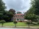 Charming two-story red brick home with lush green lawn and mature trees, enhancing curb appeal at 1098 Oakdale Ne Rd, Atlanta, GA 30307