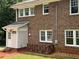 Exterior view of a red brick home with a covered entrance, white trim, and a landscaped yard at 1098 Oakdale Ne Rd, Atlanta, GA 30307