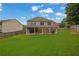 Expansive backyard view of the home showing a large, well-maintained lawn and covered patio at 280 Woods Creek Drive, Suwanee, GA 30024