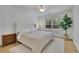 Bright bedroom featuring light hardwood floors, a cozy bed, and neutral colors at 280 Woods Creek Drive, Suwanee, GA 30024