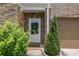 Close-up of the front entryway with a decorative wreath on the door and manicured shrubs at 280 Woods Creek Drive, Suwanee, GA 30024