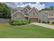 Charming two-story home featuring a manicured lawn, brick and stone accents, and a two-car garage at 280 Woods Creek Drive, Suwanee, GA 30024