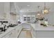 Bright kitchen with stainless steel appliances, white marble countertops, and pendant lighting over the island at 280 Woods Creek Drive, Suwanee, GA 30024