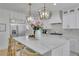 Well-lit kitchen features large island with seating, stainless steel appliances and modern white cabinetry at 280 Woods Creek Drive, Suwanee, GA 30024