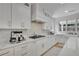 Bright kitchen features white cabinetry, quartz countertops and stainless steel appliances at 280 Woods Creek Drive, Suwanee, GA 30024