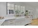 Modern white kitchen features apron sink beneath a large window offering a view of the backyard at 280 Woods Creek Drive, Suwanee, GA 30024