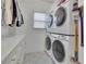 Modern laundry room features stacked washer and dryer units, patterned tile flooring, and plenty of storage at 280 Woods Creek Drive, Suwanee, GA 30024