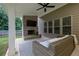 Inviting covered patio featuring a cozy fireplace, ceiling fan, and comfortable outdoor seating at 280 Woods Creek Drive, Suwanee, GA 30024