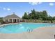 Community pool featuring ample lounge seating, mature trees, and a covered gazebo area at 280 Woods Creek Drive, Suwanee, GA 30024