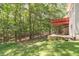 View of the backyard featuring a multi-level deck and patio surrounded by lush woods at 5581 Fox Glove Ct, Douglasville, GA 30135