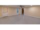 Unfinished basement with cement floor, ceiling fan, window, and white painted door at 5581 Fox Glove Ct, Douglasville, GA 30135
