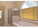 Bathroom with jetted tub, glass shower and window at 5581 Fox Glove Ct, Douglasville, GA 30135
