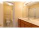 Bathroom with a shower-tub combo, toilet and wood vanity complemented by a large mirror at 5581 Fox Glove Ct, Douglasville, GA 30135