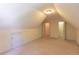 Bright attic bedroom with sloped ceilings, featuring carpet flooring and access to storage space at 5581 Fox Glove Ct, Douglasville, GA 30135