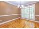 Dining room with hardwood floors, a modern chandelier, and a large window offering scenic outdoor views at 5581 Fox Glove Ct, Douglasville, GA 30135