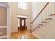 Grand foyer with hardwood floors, a staircase, and a stained-glass front door at 5581 Fox Glove Ct, Douglasville, GA 30135