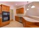 Kitchen area boasting wooden cabinets, tile floor, modern appliances, and a breakfast bar open to the living space at 5581 Fox Glove Ct, Douglasville, GA 30135