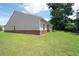 Side and back view of the home showcasing a lush, well-maintained backyard and vinyl siding at 7301 Cranleigh St, Covington, GA 30014