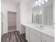 Modern bathroom featuring wood flooring, a large mirror, and a walk-in closet at 7301 Cranleigh St, Covington, GA 30014