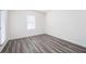Bright bedroom features modern wood-look flooring, a large window, and neutral colored walls at 7301 Cranleigh St, Covington, GA 30014