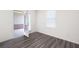 Bright bedroom featuring an open door, grey wood flooring, and a window that provides natural light at 7301 Cranleigh St, Covington, GA 30014