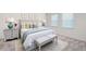 Well-lit bedroom features a comfortable bed, stylish side tables, and two windows covered in blinds at 7301 Cranleigh St, Covington, GA 30014