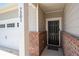 Close-up of a home's entryway featuring a stylish black door and brick accents at 7301 Cranleigh St, Covington, GA 30014
