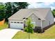 Charming home featuring a two-car garage, gray siding, and a well-manicured front lawn at 7301 Cranleigh St, Covington, GA 30014
