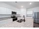 Modern kitchen with stainless appliances, granite countertops, white cabinets, and a central island with sink at 7301 Cranleigh St, Covington, GA 30014