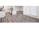 Open-concept kitchen with granite countertops, stainless steel appliances, and light grey wood flooring at 7301 Cranleigh St, Covington, GA 30014