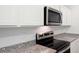 Close up of a stylish kitchen with stainless steel appliances and granite countertops with white subway tile backsplash at 7301 Cranleigh St, Covington, GA 30014