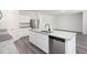 Open-concept kitchen featuring granite countertops, stainless appliances, white cabinetry, and island with sink at 7301 Cranleigh St, Covington, GA 30014