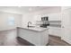 Modern kitchen boasts white cabinets, stainless steel appliances, gray granite countertops, and a central island at 7301 Cranleigh St, Covington, GA 30014