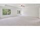 Spacious bedroom featuring a tray ceiling, large windows, and neutral carpet at 5816 Creek Indian Dr, Sugar Hill, GA 30518