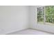 Bright bedroom featuring neutral carpet and a window with scenic views at 5816 Creek Indian Dr, Sugar Hill, GA 30518