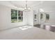 A well-lit dining room with white walls, large windows, a modern chandelier, and plush carpeting at 5816 Creek Indian Dr, Sugar Hill, GA 30518