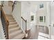 Bright foyer featuring a staircase with wood and iron railing, hardwood floors, and lots of natural light at 5816 Creek Indian Dr, Sugar Hill, GA 30518