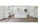 Modern kitchen featuring white cabinets, stainless steel appliances, a center island, and hardwood floors at 5816 Creek Indian Dr, Sugar Hill, GA 30518
