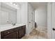 Bathroom with dark vanity, large mirror, neutral tile, and storage closet at 2015 Chapel Estates Lane Southeast Ln, Dacula, GA 30019