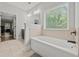 Bright bathroom features a soaking tub, tiled walls, and modern fixtures at 2015 Chapel Estates Lane Southeast Ln, Dacula, GA 30019