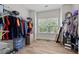 Spacious walk-in closet with an open shelving, a window, and laminate floors at 2015 Chapel Estates Lane Southeast Ln, Dacula, GA 30019