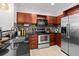 Modern kitchen featuring granite countertops, stainless steel appliances, and warm wood cabinetry at 390 17Th Nw St # 4031, Atlanta, GA 30363