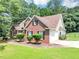 Beautiful brick home with attached garage, complemented by a green lawn and mature trees, exuding classic charm at 401 Crosshaven Way, Mcdonough, GA 30253