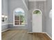 Bright foyer featuring hardwood floors, a large arched window, and a classic chandelier, creating an inviting entrance at 401 Crosshaven Way, Mcdonough, GA 30253