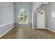 Bright foyer featuring hardwood floors, a large arched window, and a classic chandelier, creating an inviting entrance at 401 Crosshaven Way, Mcdonough, GA 30253