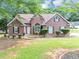 Charming brick home featuring a manicured lawn and mature landscaping, creating a welcoming curb appeal at 401 Crosshaven Way, Mcdonough, GA 30253