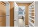 Spacious walk-in closet with built-in shelving and open access to a double vanity bathroom with separate soaking tub at 401 Crosshaven Way, Mcdonough, GA 30253